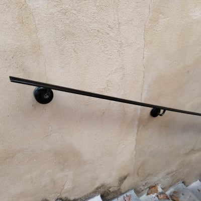 מעקה מתכת שחור על קיר בטון