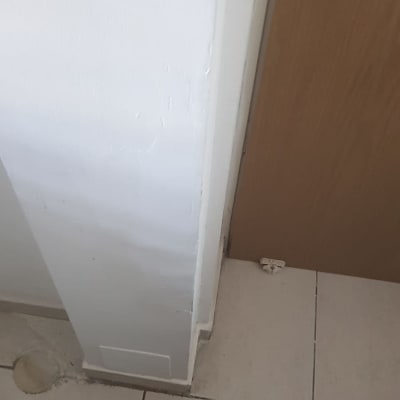 קיר צבוע בלבן ליד דלת עץ