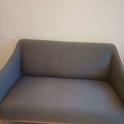 ספה אפורה עם מסגרת עץ על רצפת שיש