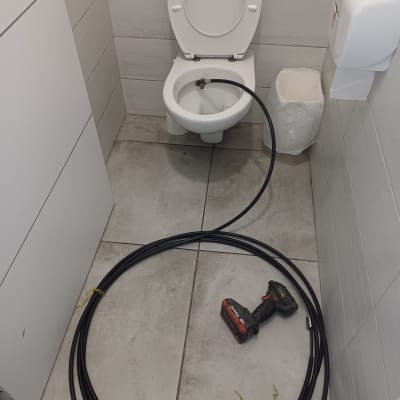 כבל שחור וכלי עבודה ליד אסלה בשירותים