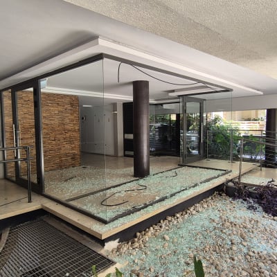 זכוכית שבורה על הרצפה ליד מבנה זכוכית