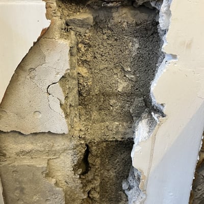 צינור חשוף בקיר עם טיח מתקלף