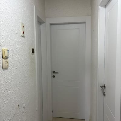 מסדרון עם דלתות לבנות וקירות מחוספסים