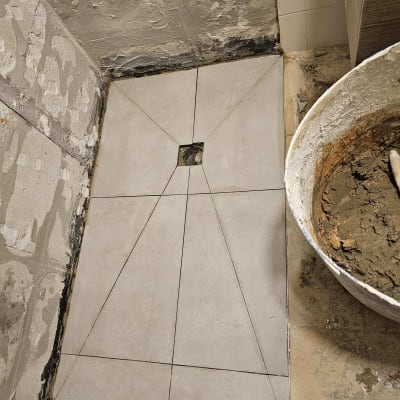 ריצוף חדש בתהליך שיפוץ עם דלי מלט