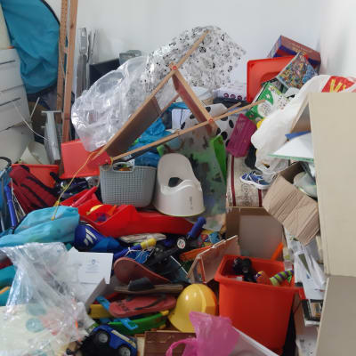 חדר מבולגן עם צעצועים, קופסאות ופריטים מפוזרים