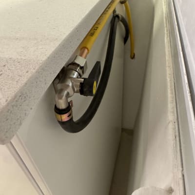 צינור גז צהוב ושחור מחובר לשסתום מתכת