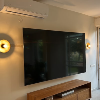 טלוויזיה תלויה על הקיר עם תאורה וסלון