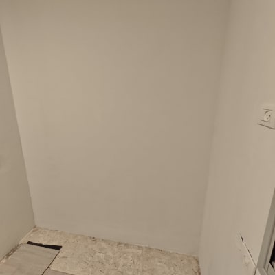 רצפת פרקט מותקנת בחדר עם קיר לבן