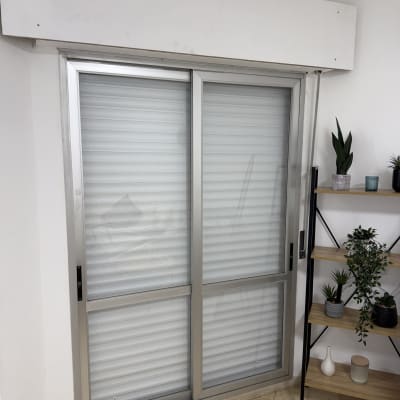 תריסים אלומיניום מותקנים על חלון בחדר פנימי