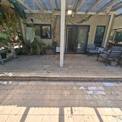 מרפסת עץ עם צמחייה וריהוט גן