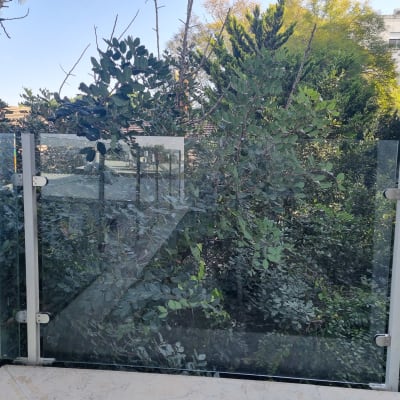 מעקה זכוכית עם נוף של עצים ברקע