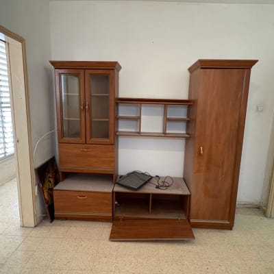 ארון עץ עם מדפים ודלתות זכוכית בחדר ריק