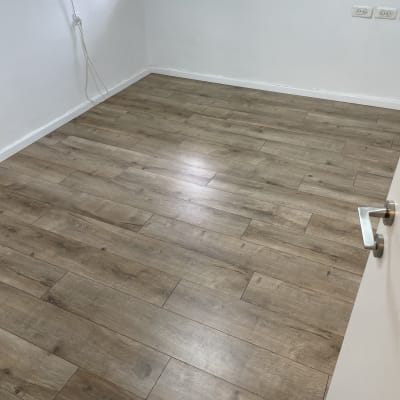 רצפת פרקט עץ בחדר ריק עם קירות לבנים