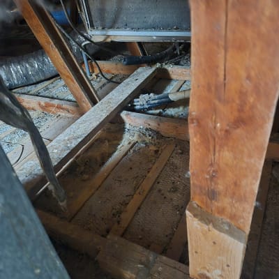 תמונה של אזור מלוכלך עם קורות עץ ואבק