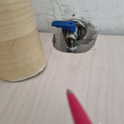 ברז עם ידית כחולה בקיר לבן