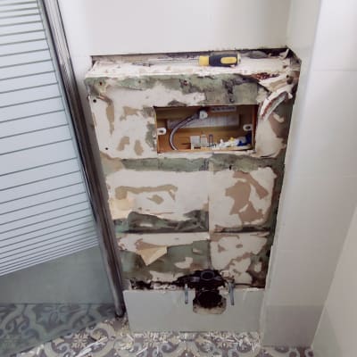 קיר פתוח עם צנרת וכלי עבודה בשיפוץ חדר אמבטיה