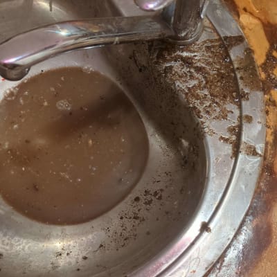 כיור סתום עם מים מלוכלכים וברז מתכת