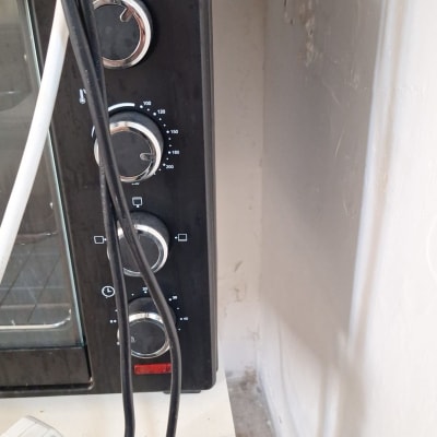 תנור עם כפתורים וכבלים מחוברים לשקע