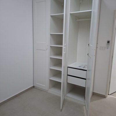 ארון לבן עם דלתות פתוחות ומדפים פנימיים