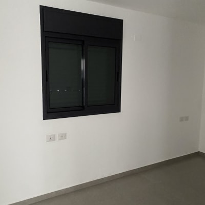 קיר לבן עם חלון סגור ורצפה נקייה