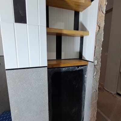 מדפים מעץ מותקנים בנישה עם קירות לבנים