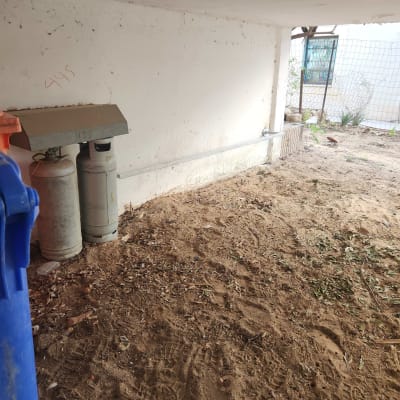 שני בלוני גז ליד קיר לבן עם מסגרת חלון