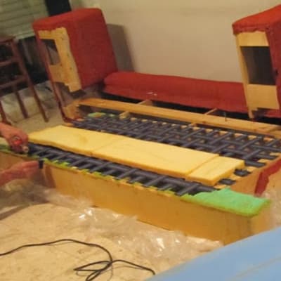 אדם מרפד ספה עם קצף וכלי עבודה