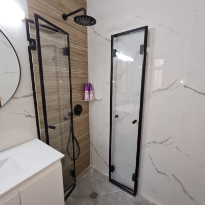 מקלחון זכוכית עם מסגרת שחורה וברז גשם