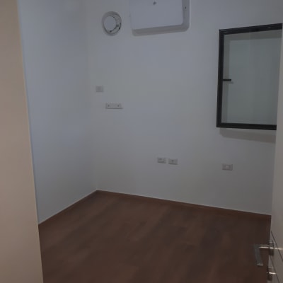 חדר עם קירות לבנים ורצפת עץ כהה