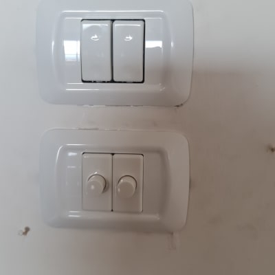 שני מתגי חשמל לבנים על קיר לבן