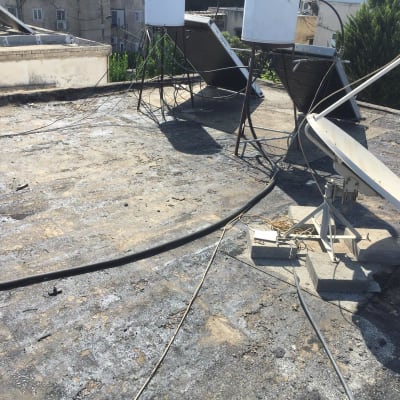 גג עם ציפוי איטום, כבלים וצלחת לוויין