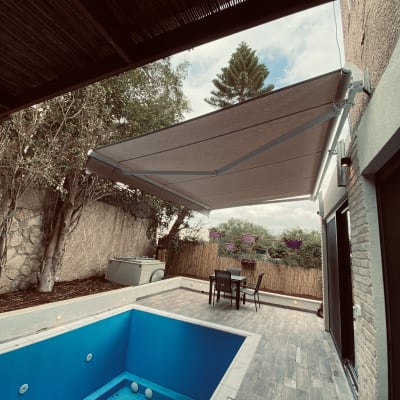 סוכך בד מתכת מותקן מעל מרפסת חיצונית