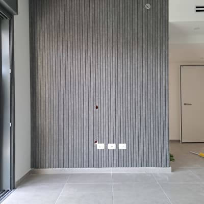 קיר מחופה בלוחות אפורים עם שקעים חשמליים