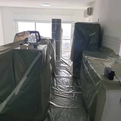 חדר מכוסה ביריעות פלסטיק ירוקות עם סרטי הדבקה