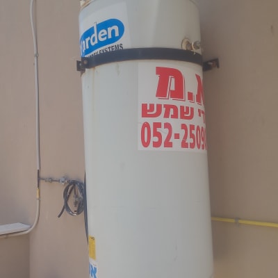 דוד שמש מותקן על קיר עם צינורות וחיבורים