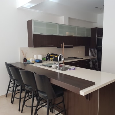 מטבח מודרני עם דלפק וכיסאות בר שחורים