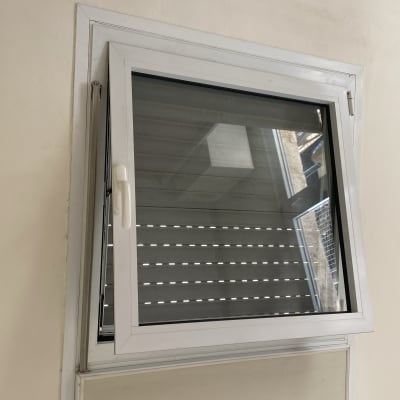 חלון אלומיניום פתוח עם מסגרת לבנה