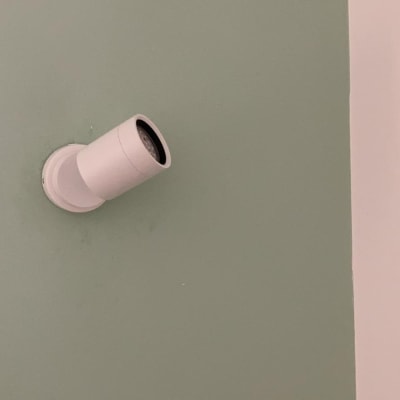 תאורת קיר לבנה מותקנת על קיר ירוק