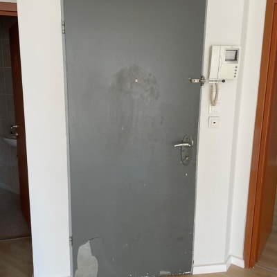 דלת אפורה עם קילופי צבע ותיקון נדרש