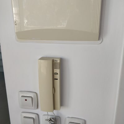 אינטרקום על קיר לבן עם מתגי חשמל