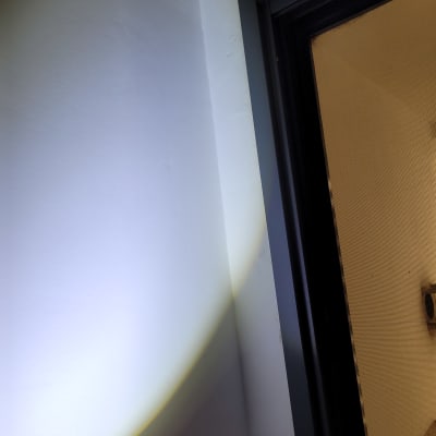 קיר מואר בפנס ליד מסגרת דלת כהה