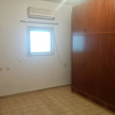 חדר ריק עם קיר לבן וארון עץ