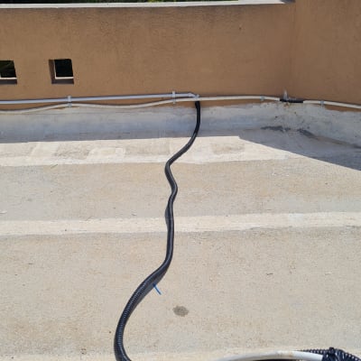 כבלים חשמליים מונחים על גג עם צינור פלסטיק