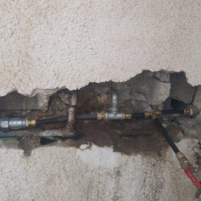 צינורות מתכת וברזים בקיר שבור