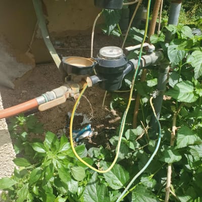 חוטי חשמל צבעוניים מחוברים לצינורות ומד מים