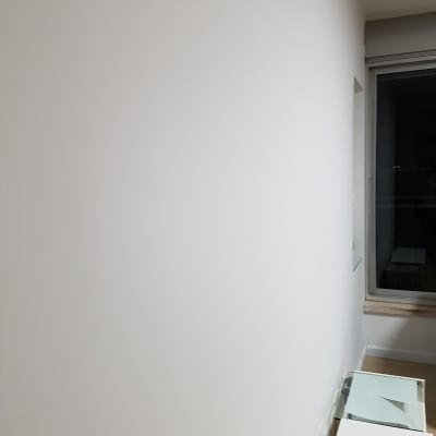 קיר לבן חלק עם שולחן זכוכית ליד חלון