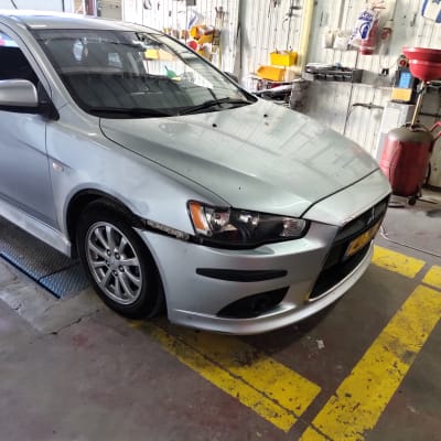 רכב עם פגוש קדמי פגום במוסך תיקונים