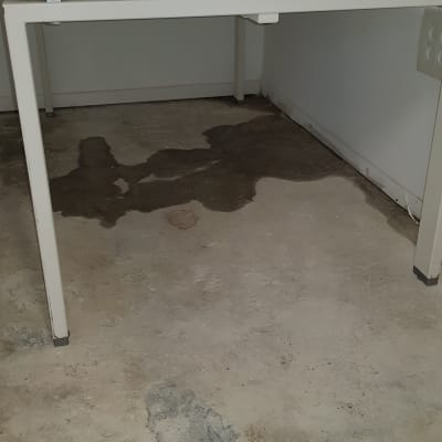 רצפה רטובה עם סימני נזילה מתחת לשולחן