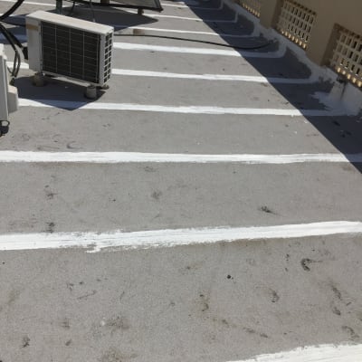 פסי איטום לבנים על גג בטון אפור