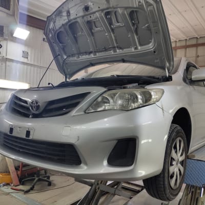 רכב על מעלית עם מכסה מנוע פתוח במוסך